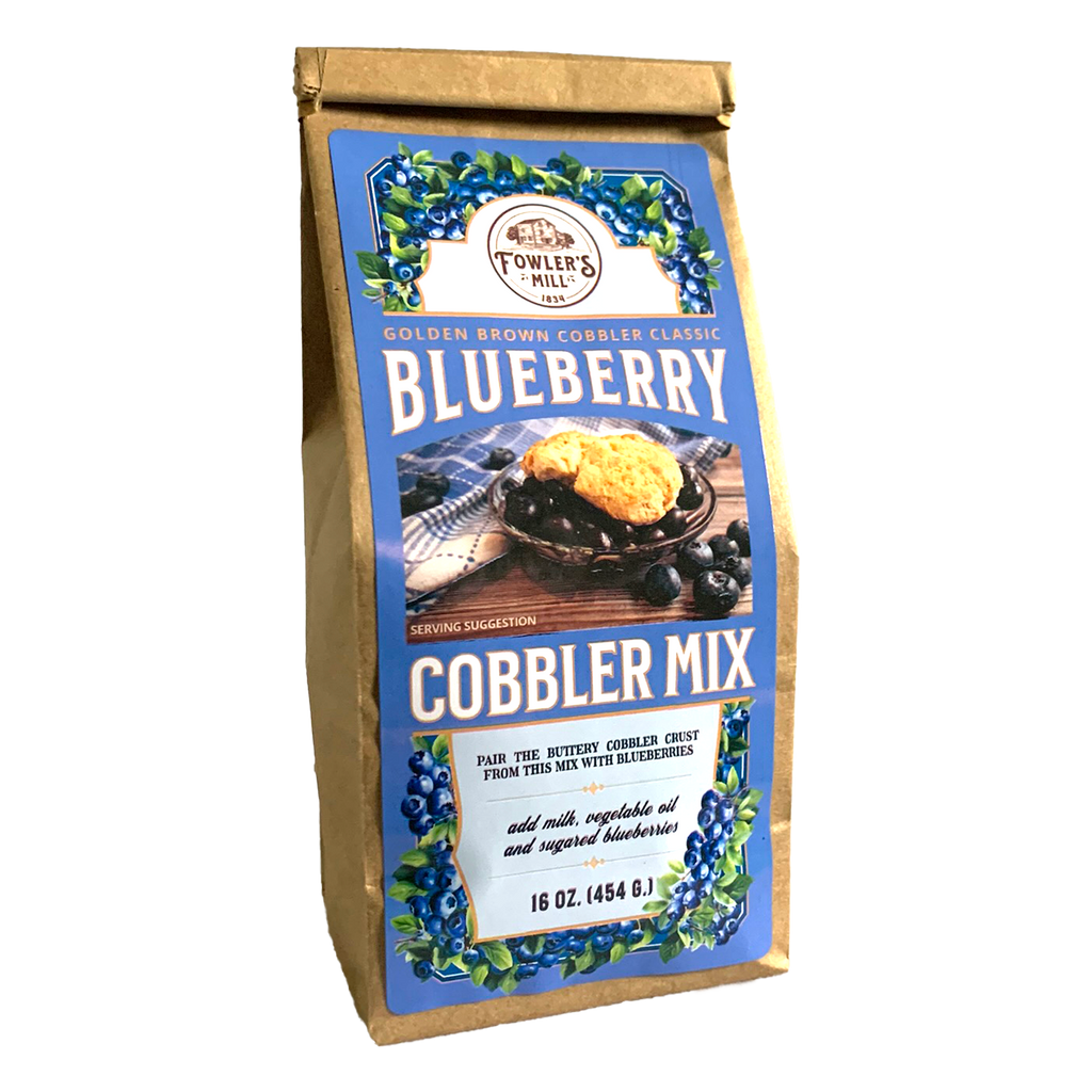 Front of Fowler's Mill Blueberry Cobbler Mix paper bag with glossy label including a pile of blueberries and a bowl of warm blueberry cobbler