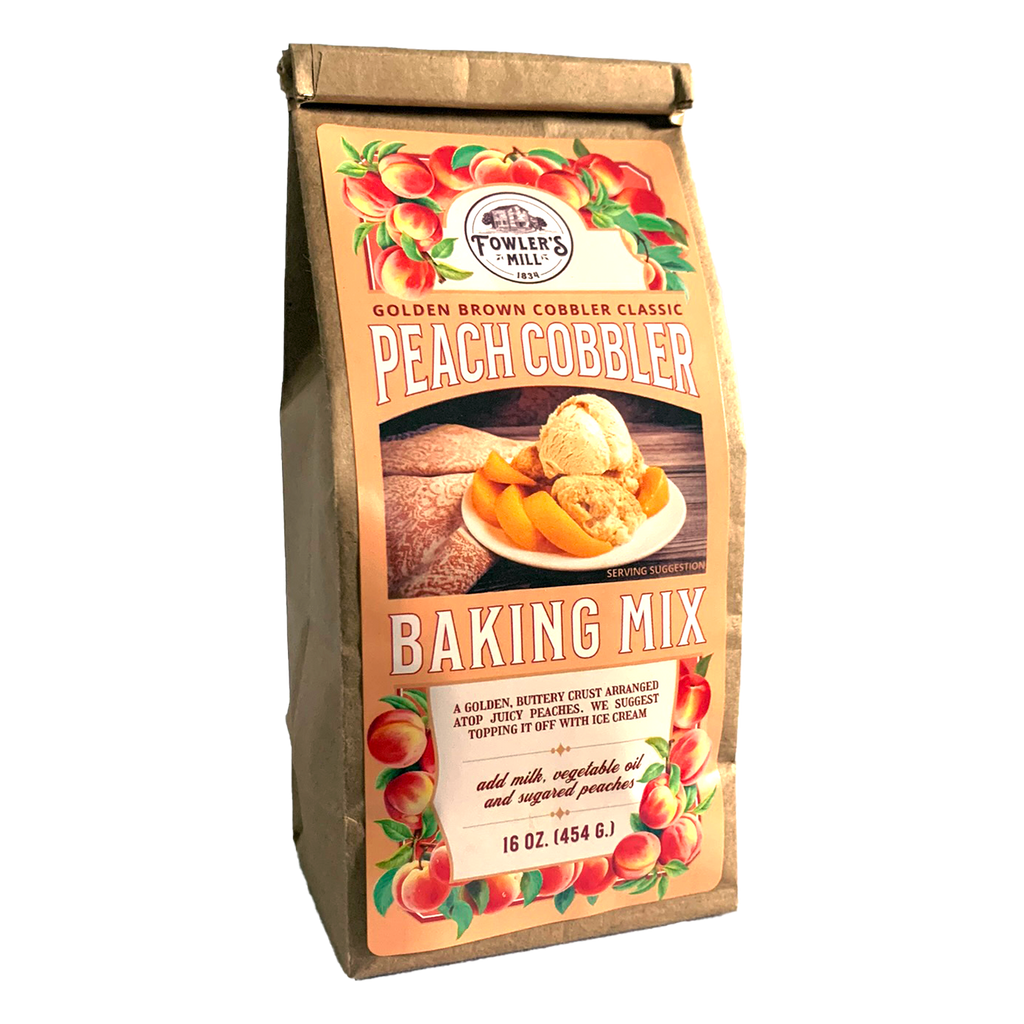 Front of Fowler's Mill Peach Cobbler Mix kraft paper bag with glossy label showing a pile of fresh peaches and a peach cobbler with vanilla ice cream