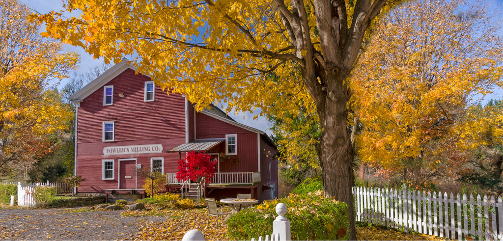 Fowler's Mill, a three story red building, on a sunny autumn day.